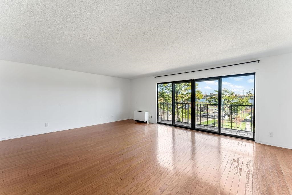 1150 River Road, Unit 4F Edgewater, NJ 07020 - Photo 4 of 20 wooden floor in an empty room with a window