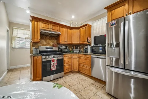 a kitchen with stainless steel appliances granite countertop a refrigerator stove and sink