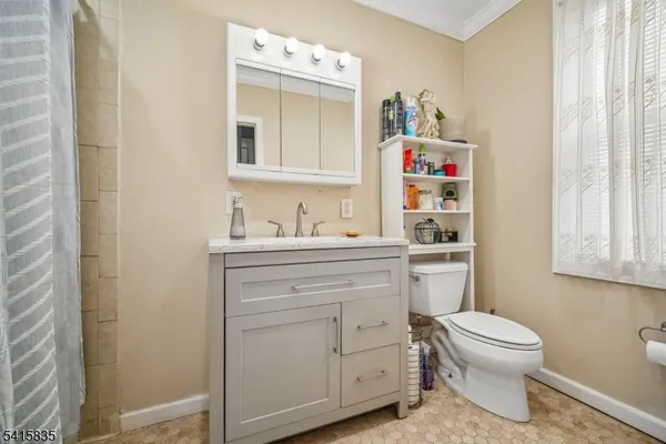 a bathroom with a toilet sink vanity and mirror