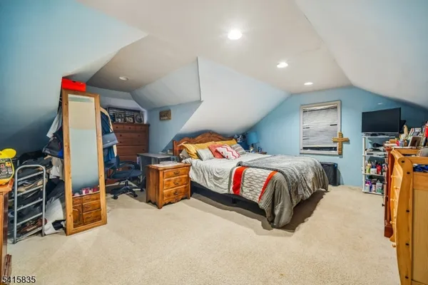 a bedroom with a bed and a flat tv screen