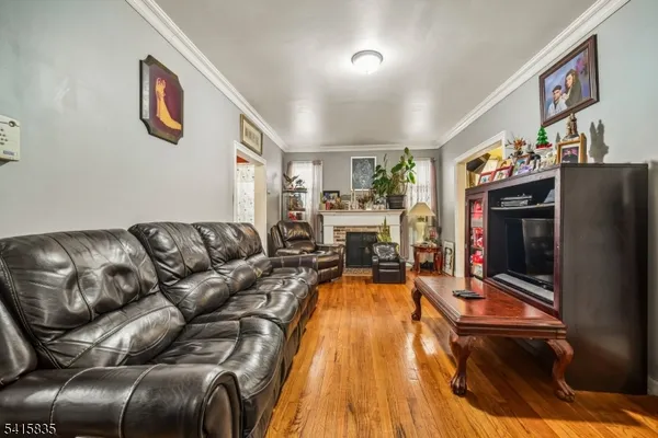 a living room with furniture a flat screen tv and kitchen view