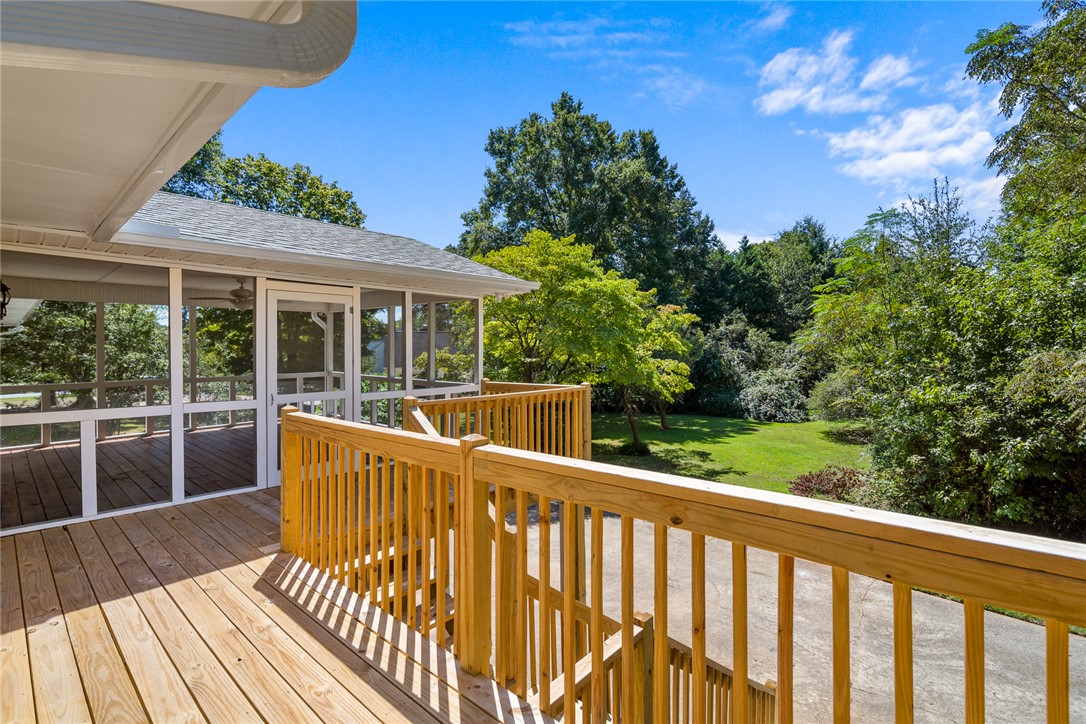 208 Williamsburg Road Anderson, SC 29621 - Photo 45 of 48 An elevated wooden deck overlooks a grassy backyard surrounded by mature trees.