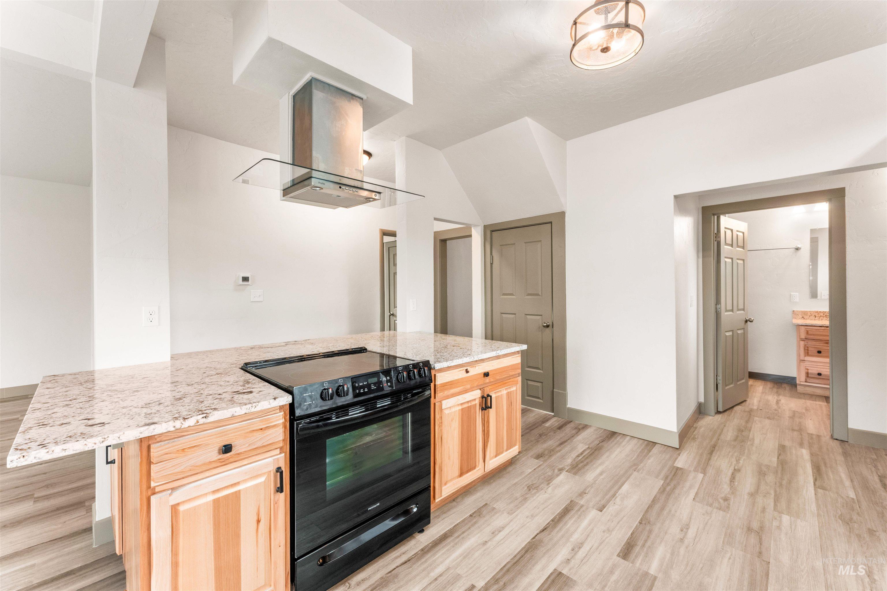 602 North 5th Street Parma, ID 83660 - Photo 18 of 48 Kitchen with light brown cabinetry, electric range, a center island, light wood finished floors, and exhaust hood