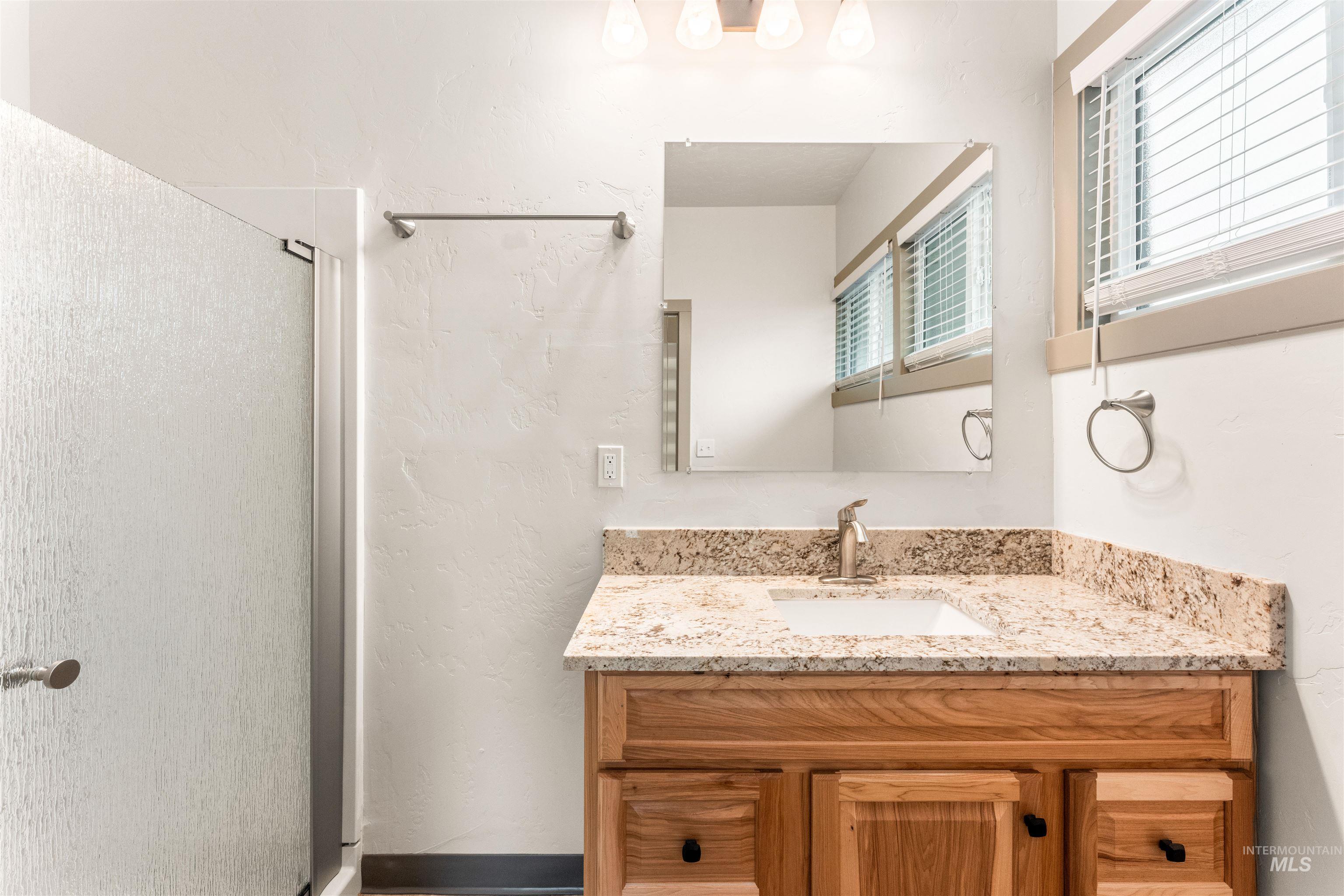 602 North 5th Street Parma, ID 83660 - Photo 27 of 48 Bathroom with a textured wall, a shower stall, and vanity