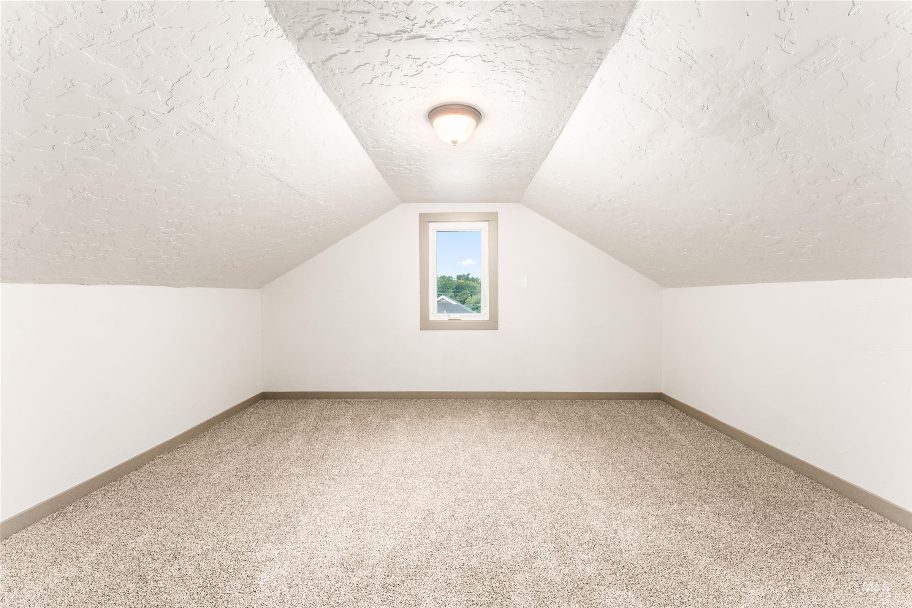 602 North 5th Street Parma, ID 83660 - Photo 34 of 48 Bonus room featuring a textured ceiling, carpet flooring, and lofted ceiling
