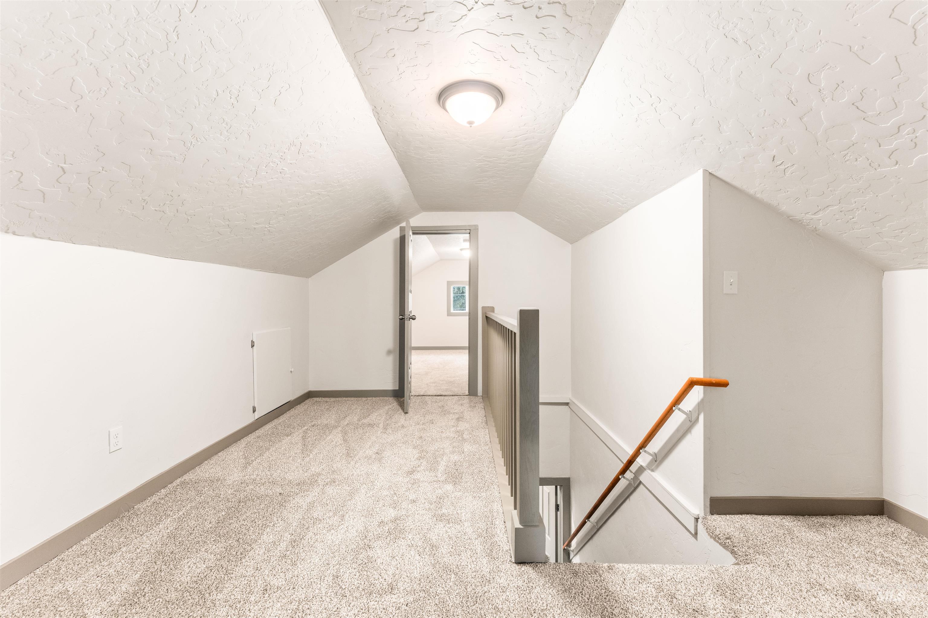 602 North 5th Street Parma, ID 83660 - Photo 36 of 48 Bonus room with light carpet, a textured ceiling, and vaulted ceiling