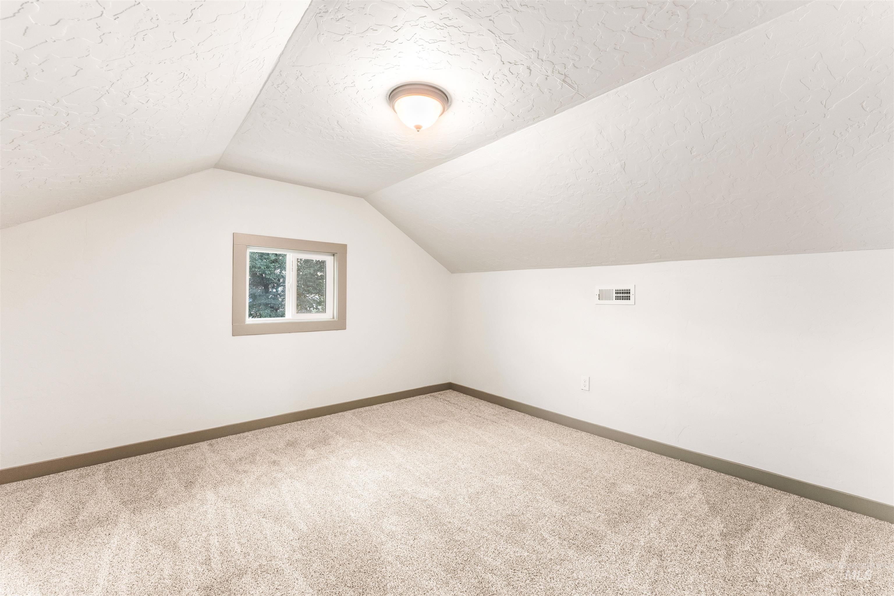 602 North 5th Street Parma, ID 83660 - Photo 37 of 48 Bonus room with carpet, lofted ceiling, and a textured ceiling
