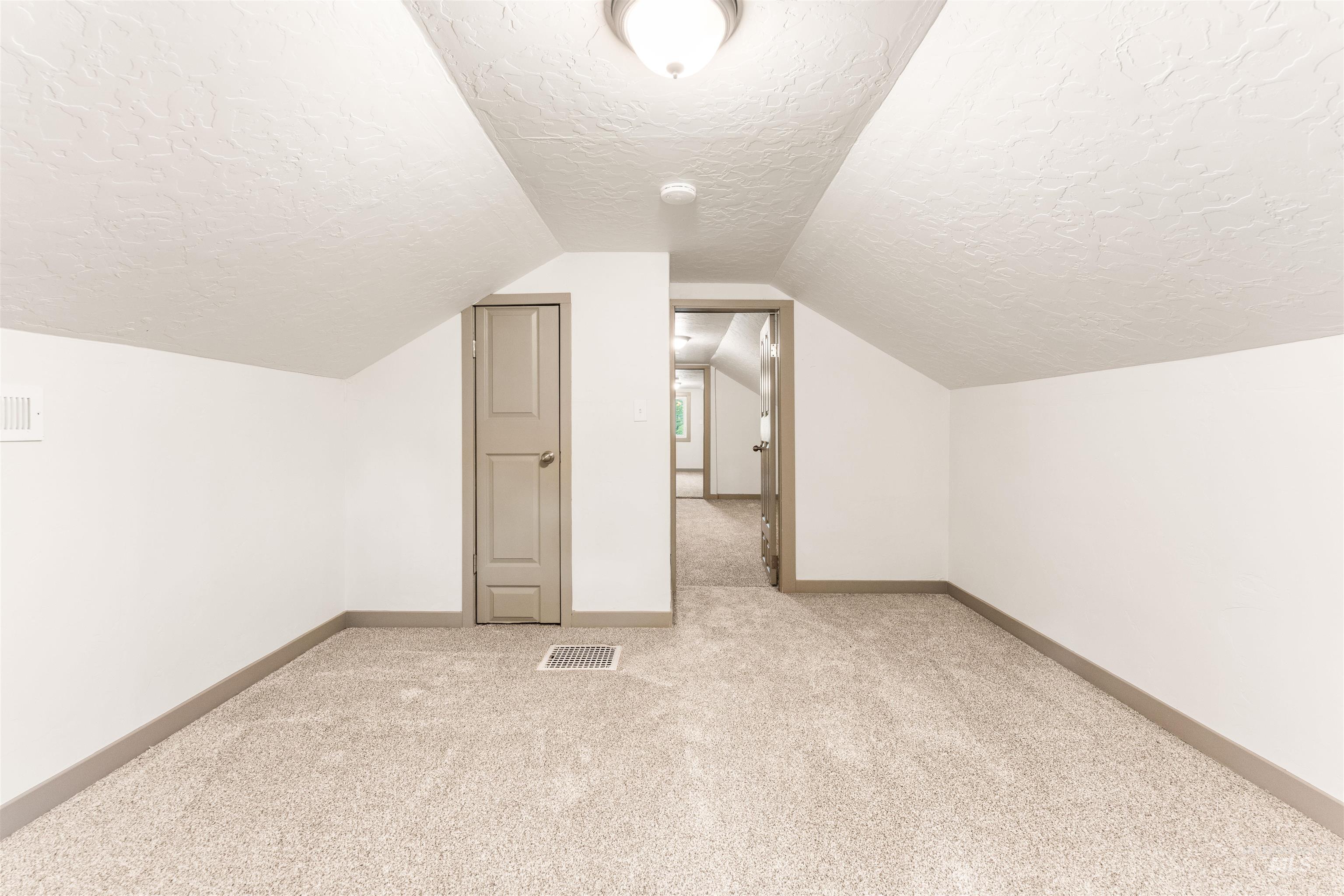 602 North 5th Street Parma, ID 83660 - Photo 38 of 48 Bonus room with light colored carpet, vaulted ceiling, and a textured ceiling
