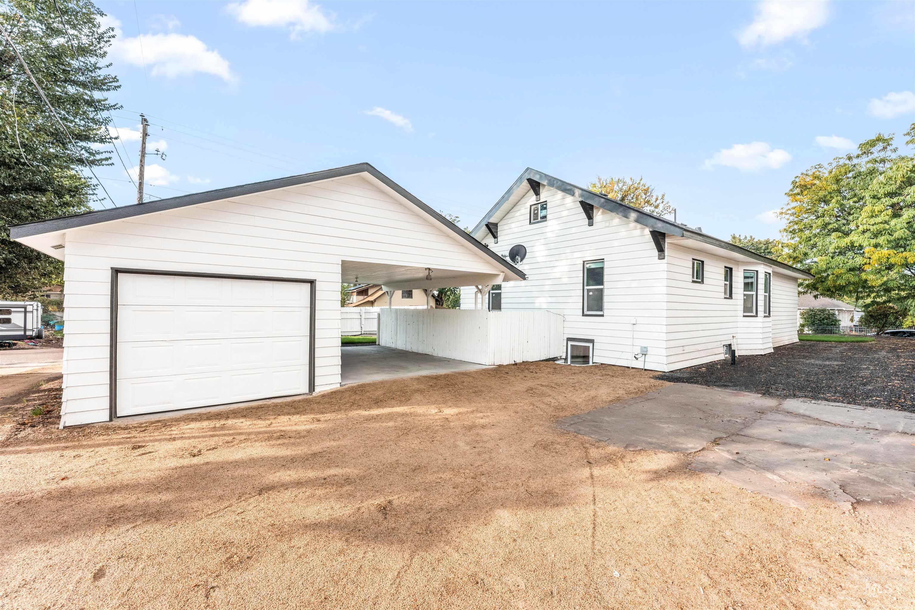 602 North 5th Street Parma, ID 83660 - Photo 8 of 48 Rear view of property with a patio area, an outdoor structure, driveway, and a garage