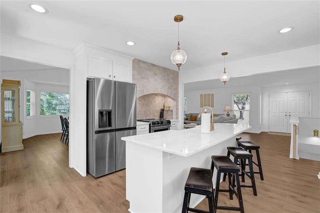 889 Fawn Way Marietta, GA 30068 - Photo 12 of 30 a kitchen with stainless steel appliances a refrigerator a stove a dining table and chairs with wooden floor