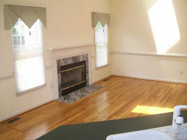 6301 Ashley Ridge Drive Raleigh, NC 27612 - Photo 4 of 12 a view of empty room with wooden floor and fan