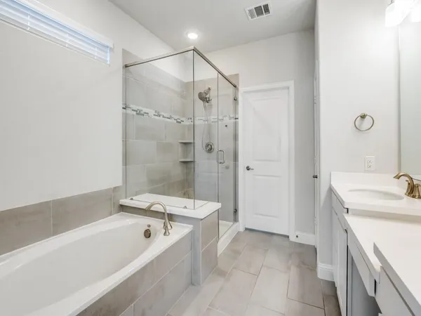a bathroom with a tub a sink and a large mirror
