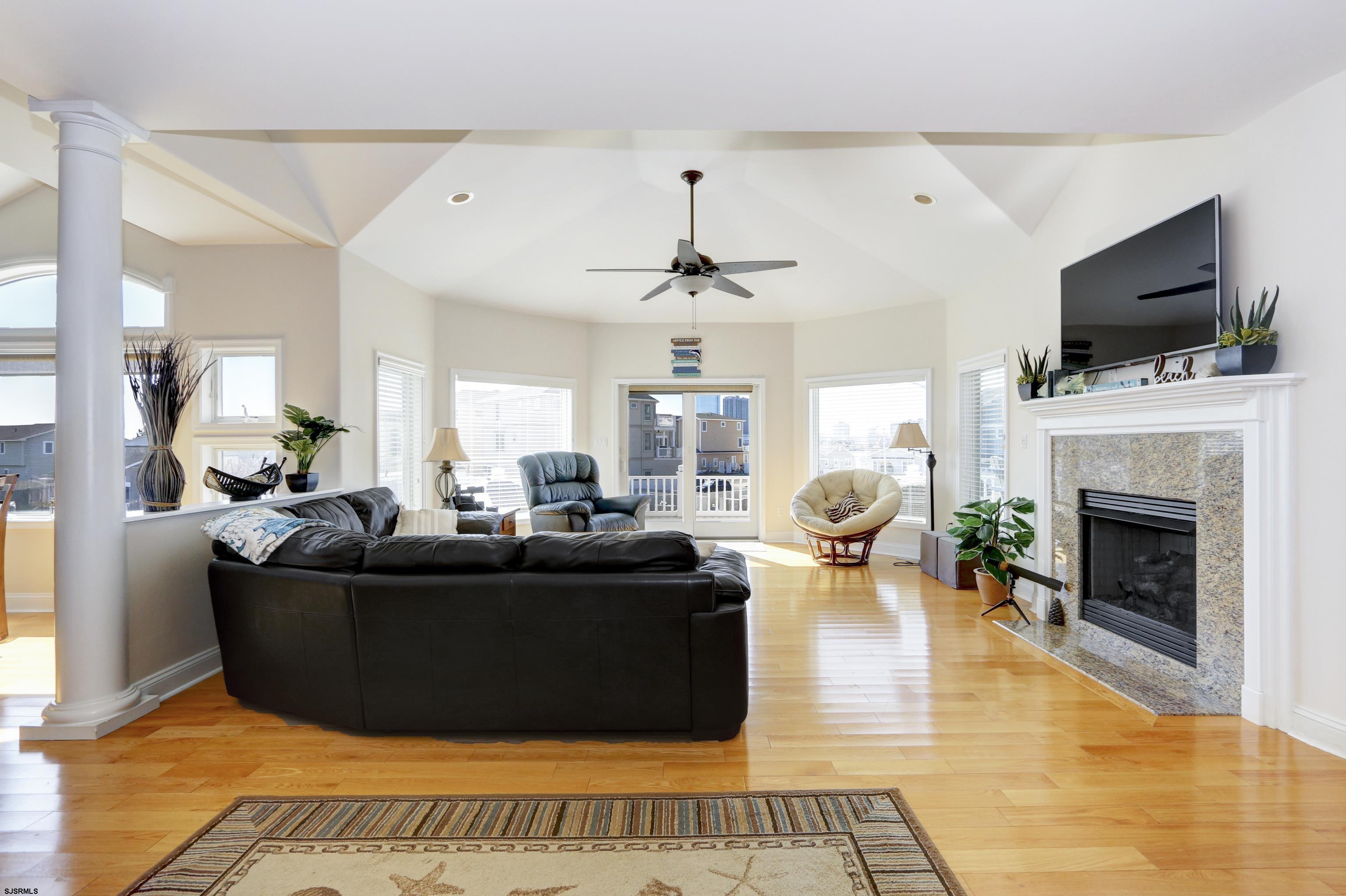 5219 Seaspray Road Brigantine, NJ 08203 - Photo 17 of 39 a living room with furniture a flat screen tv and a fireplace