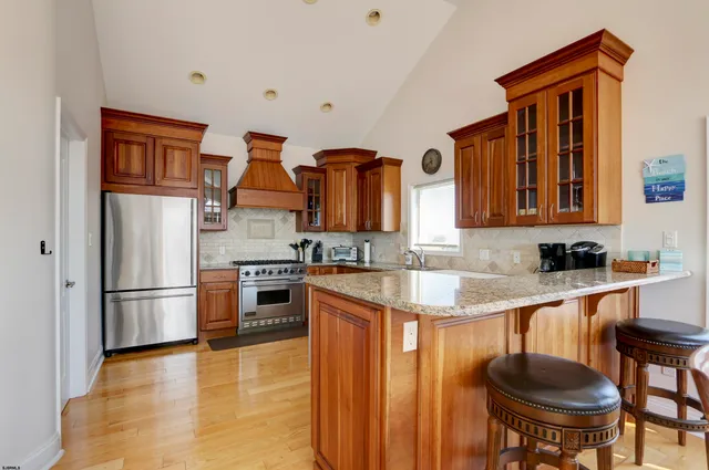 a kitchen with stainless steel appliances granite countertop a refrigerator and a stove top oven
