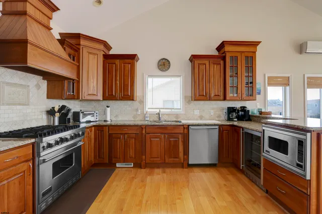a kitchen with stainless steel appliances granite countertop a stove a sink and a refrigerator