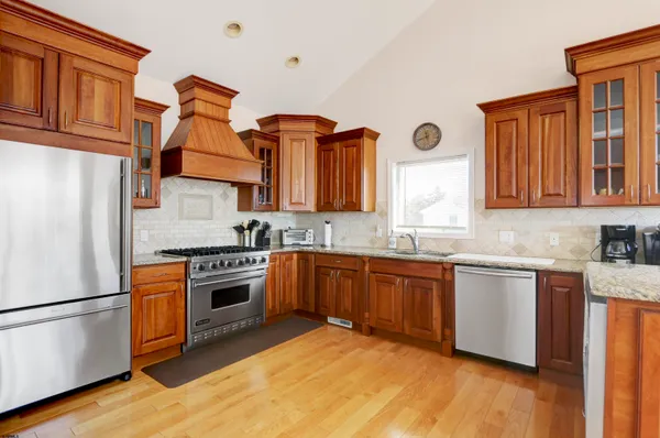 a kitchen with stainless steel appliances granite countertop a refrigerator and a stove top oven