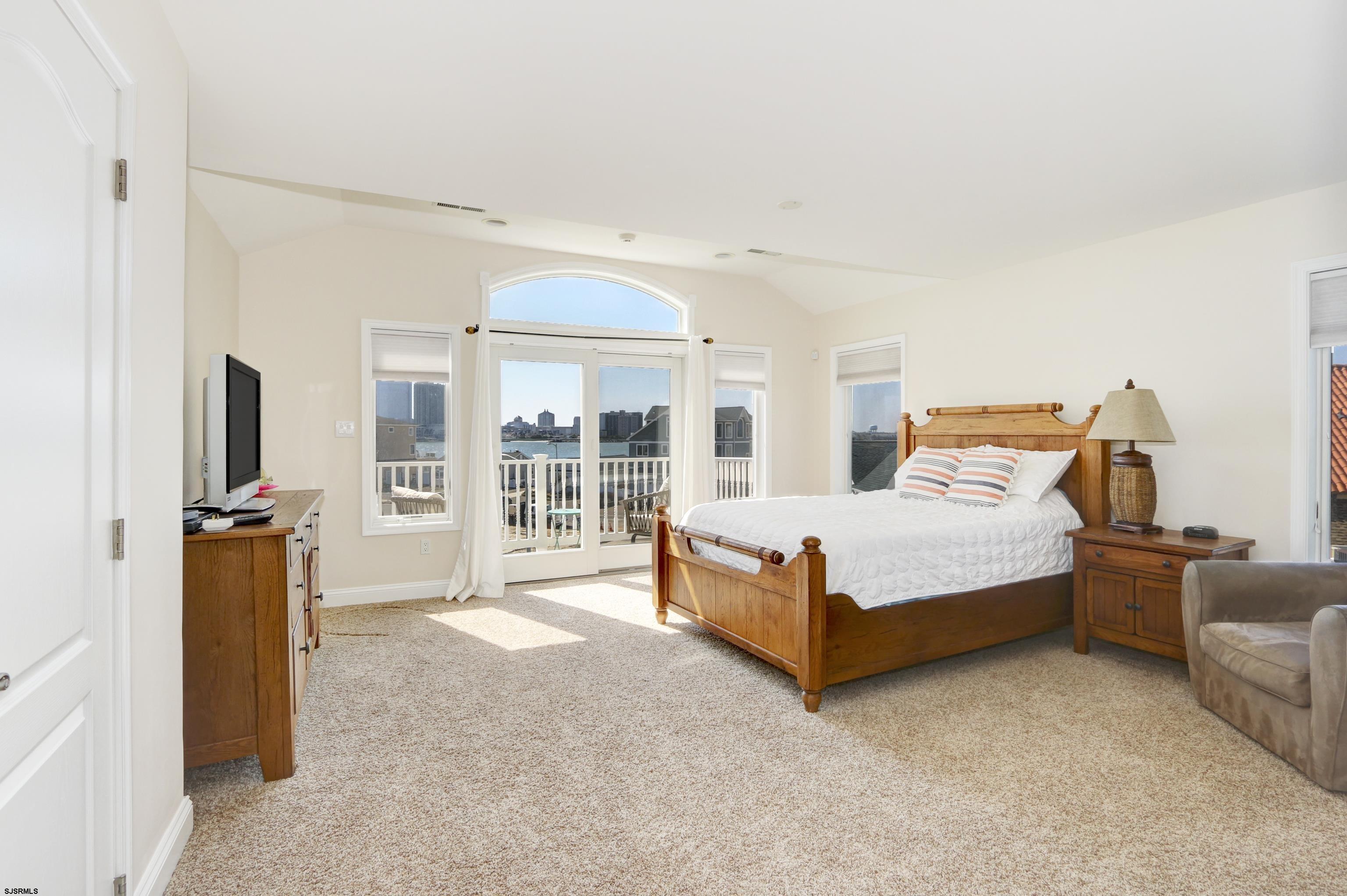 5219 Seaspray Road Brigantine, NJ 08203 - Photo 27 of 39 a bedroom with a bed and glass door