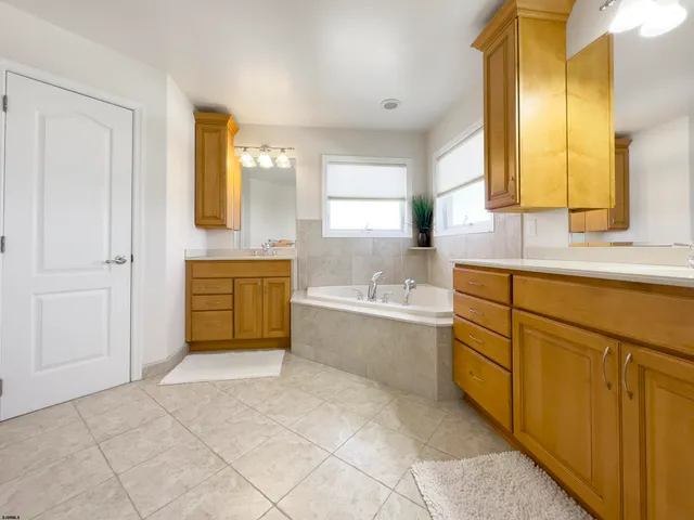 a bathroom with a tub sink and mirror