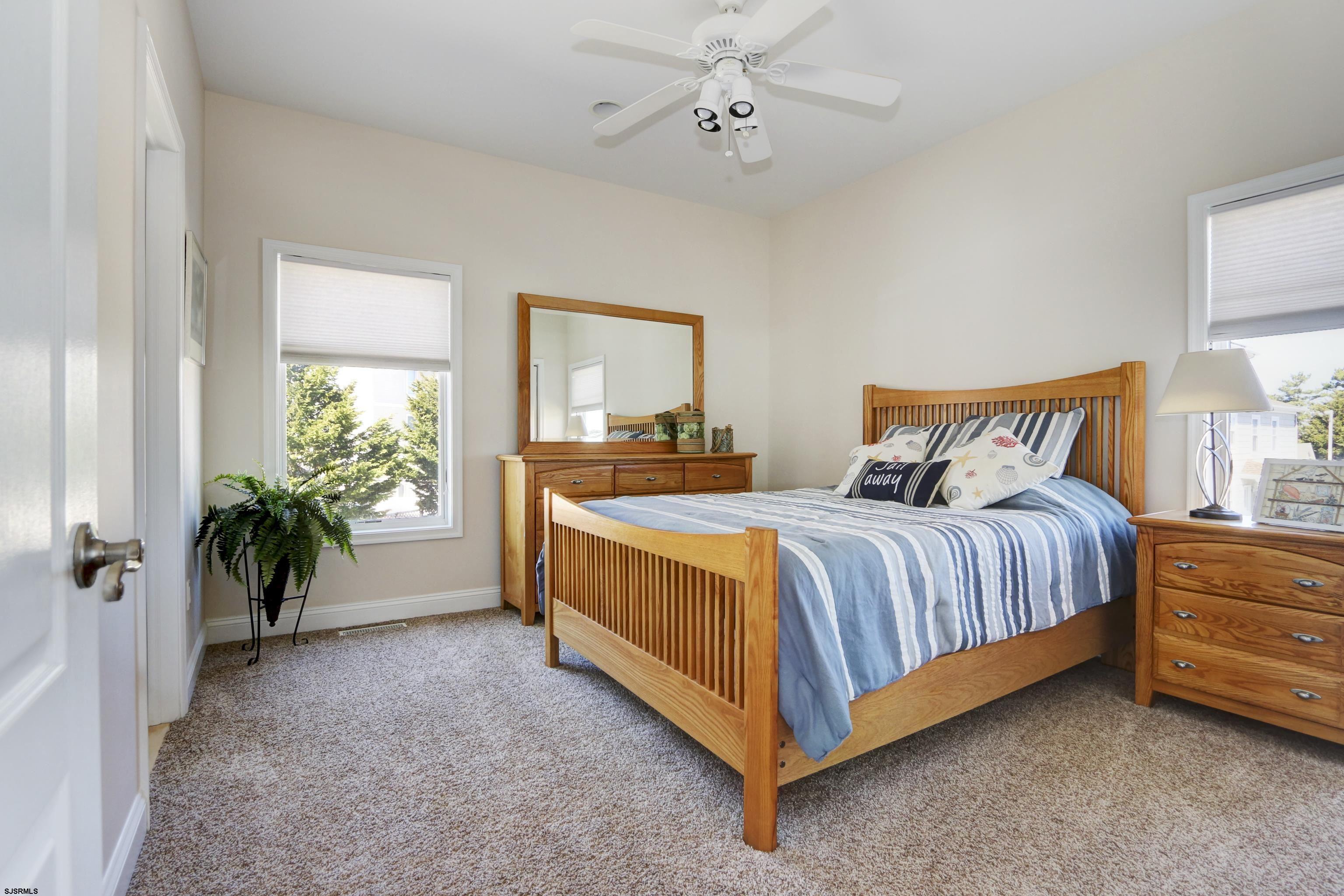 5219 Seaspray Road Brigantine, NJ 08203 - Photo 30 of 39 a spacious bedroom with a bed and a potted plant