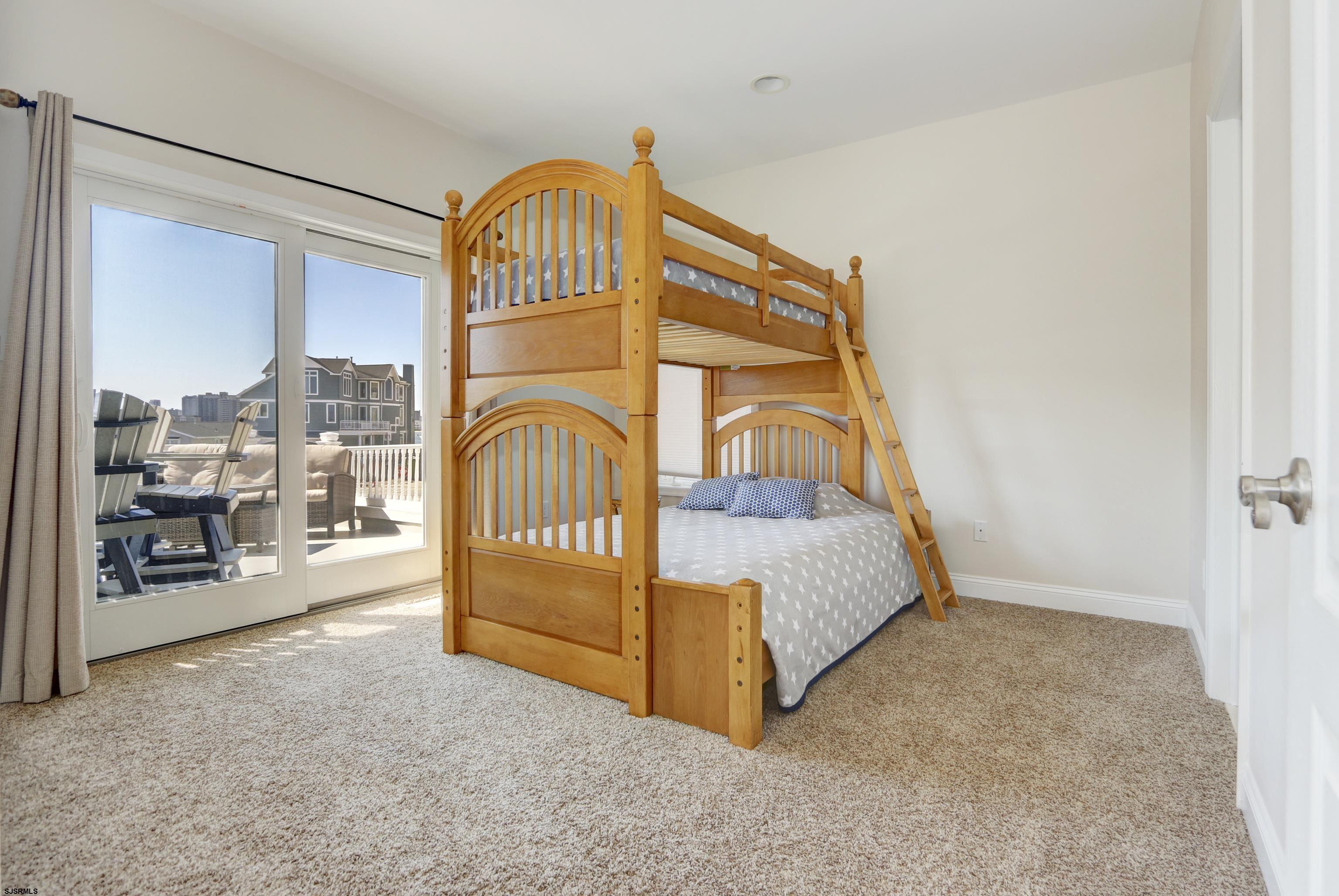 5219 Seaspray Road Brigantine, NJ 08203 - Photo 31 of 39 a view of a bedroom with a bed and the porch