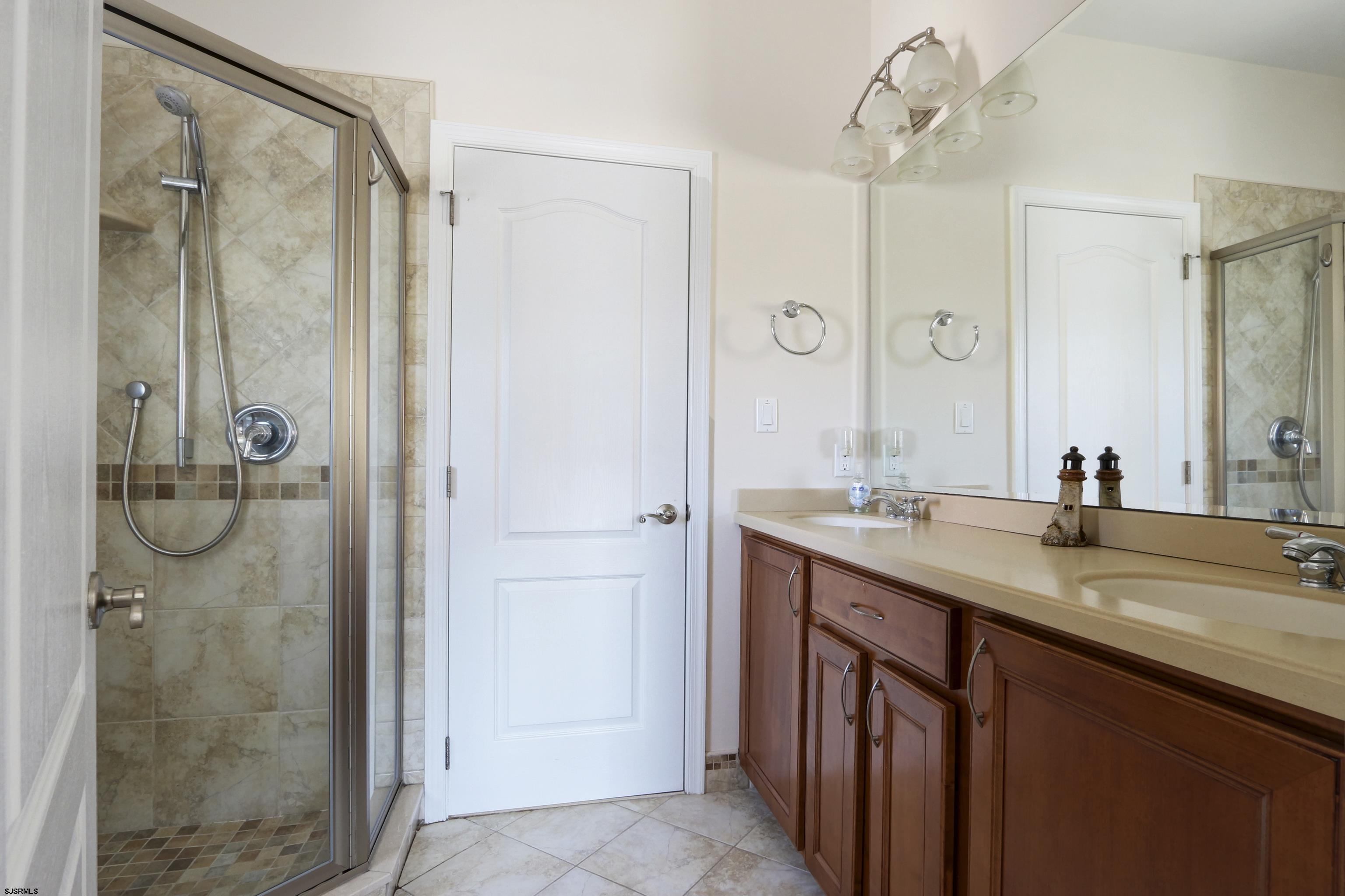 5219 Seaspray Road Brigantine, NJ 08203 - Photo 32 of 39 a bathroom with a granite countertop shower sink and mirror