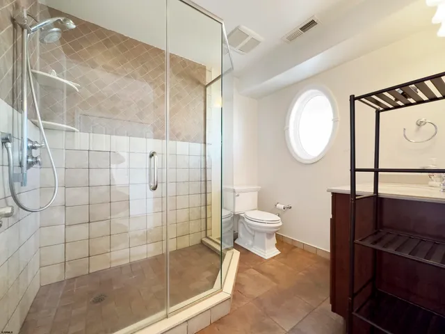 a bathroom with a toilet mirror and shower