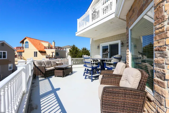 a view of a patio with couches table and chairs and wooden floor