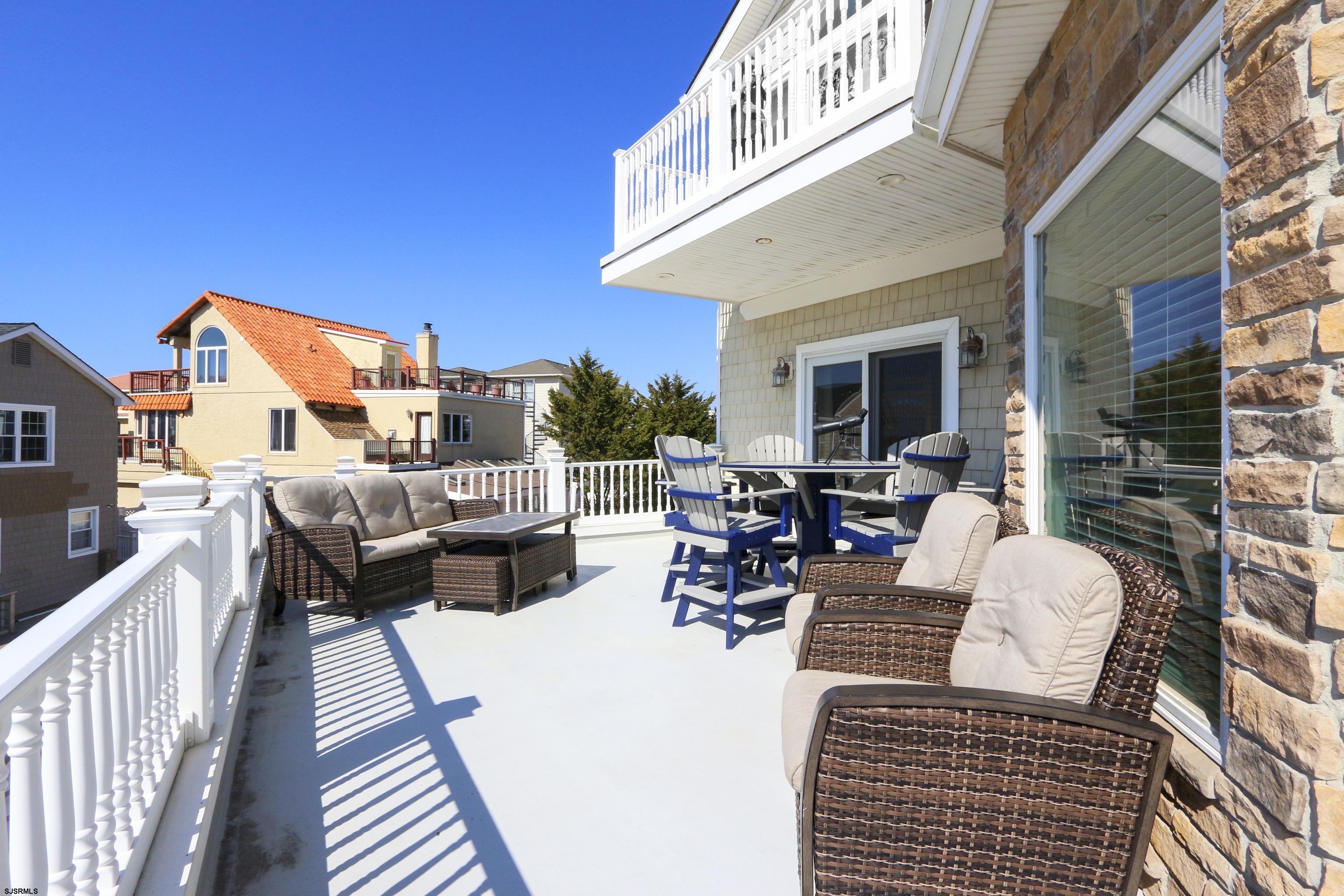 5219 Seaspray Road Brigantine, NJ 08203 - Photo 6 of 39 a view of a patio with couches table and chairs and wooden floor