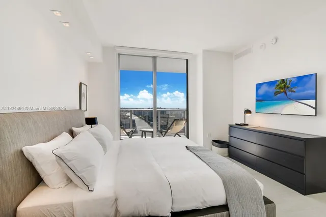 a bedroom with a bed and a flat screen tv