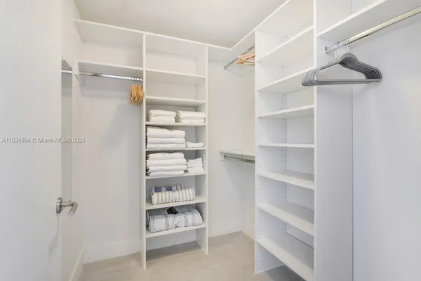 a view of walk in closet with empty racks