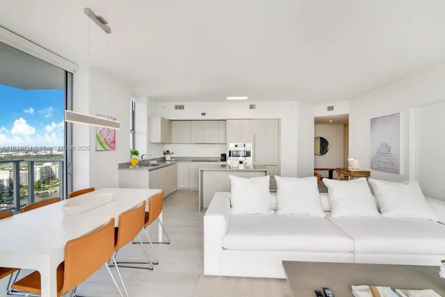 a living room with stainless steel appliances kitchen island granite countertop furniture and a large window