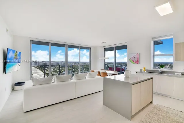 a living room with kitchen island furniture and a large window