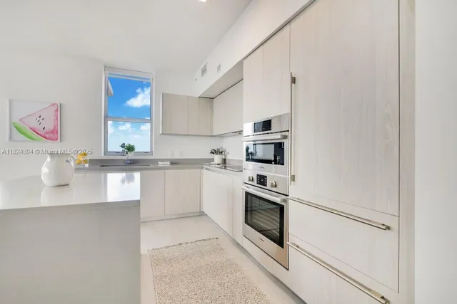 a kitchen with granite countertop white cabinets and stainless steel appliances