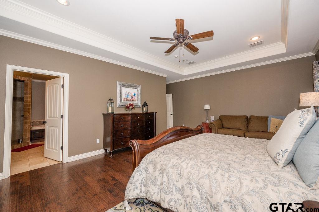 8553 Castleton Way Tyler, TX 75703 - Photo 21 of 38 a bedroom with a bed and a chandelier