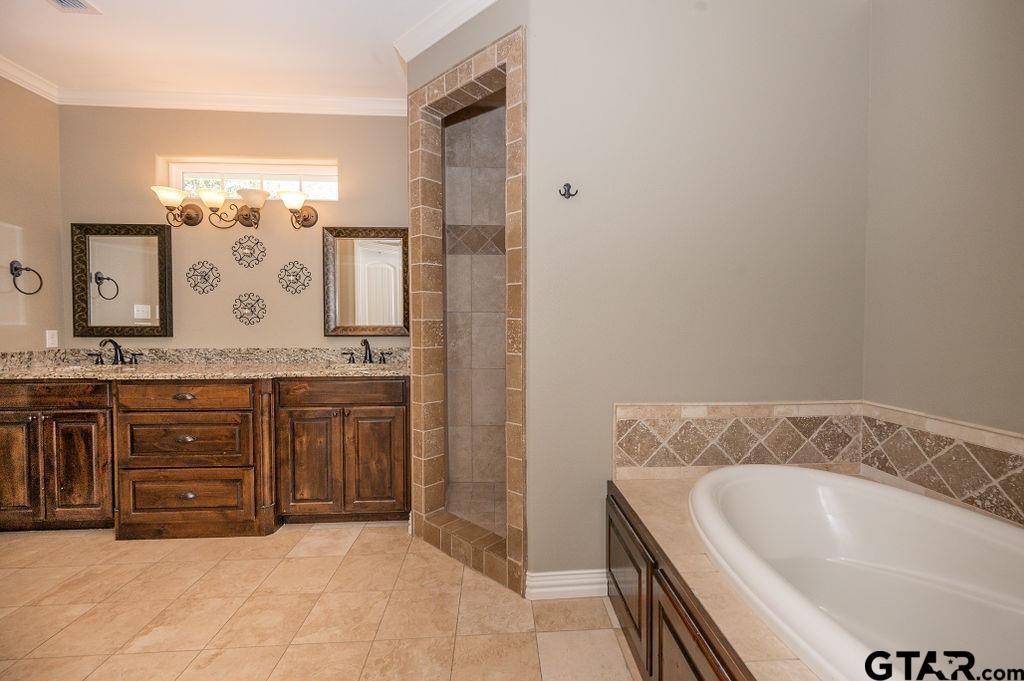 8553 Castleton Way Tyler, TX 75703 - Photo 23 of 38 a bathroom with a bathtub sink and mirror