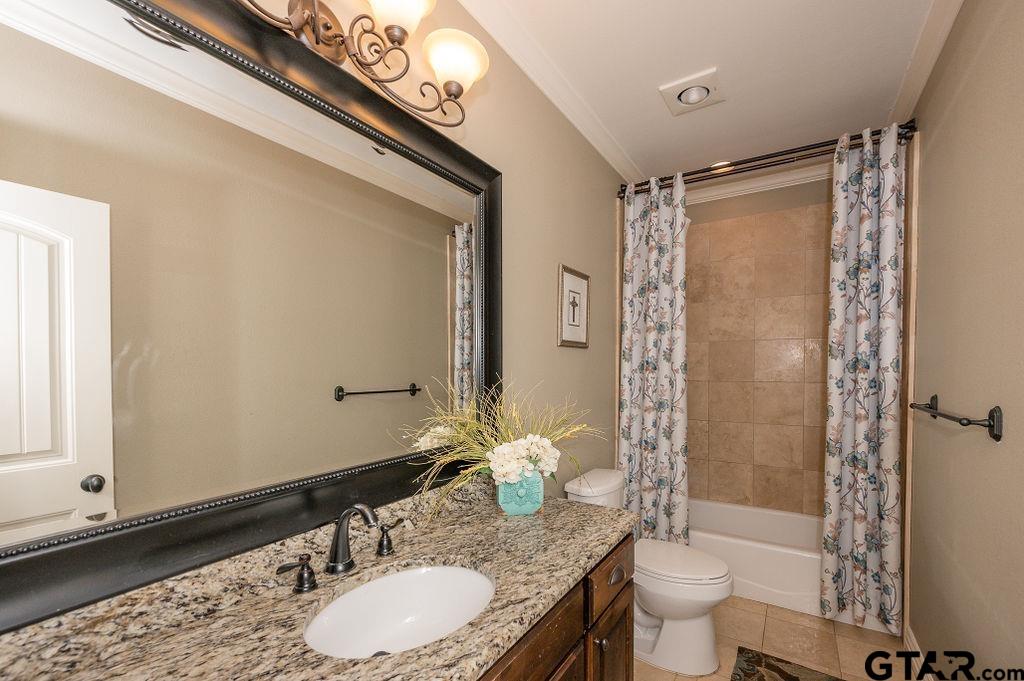 8553 Castleton Way Tyler, TX 75703 - Photo 26 of 38 a bathroom with a granite countertop sink toilet a mirror and shower