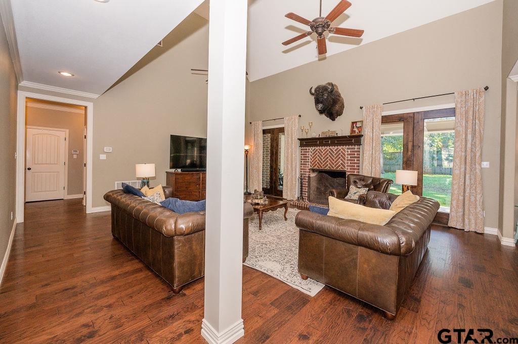 8553 Castleton Way Tyler, TX 75703 - Photo 7 of 38 a living room with furniture a fireplace and a chandelier