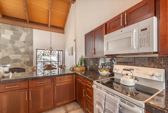 a kitchen with stainless steel appliances granite countertop a sink stove and cabinets