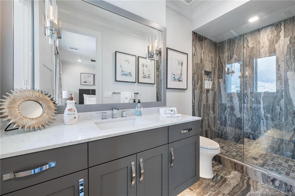 4860 Watersong Way Fort Pierce, FL 34949 - Photo 23 of 45 a bathroom with a double vanity sink toilet and a mirror