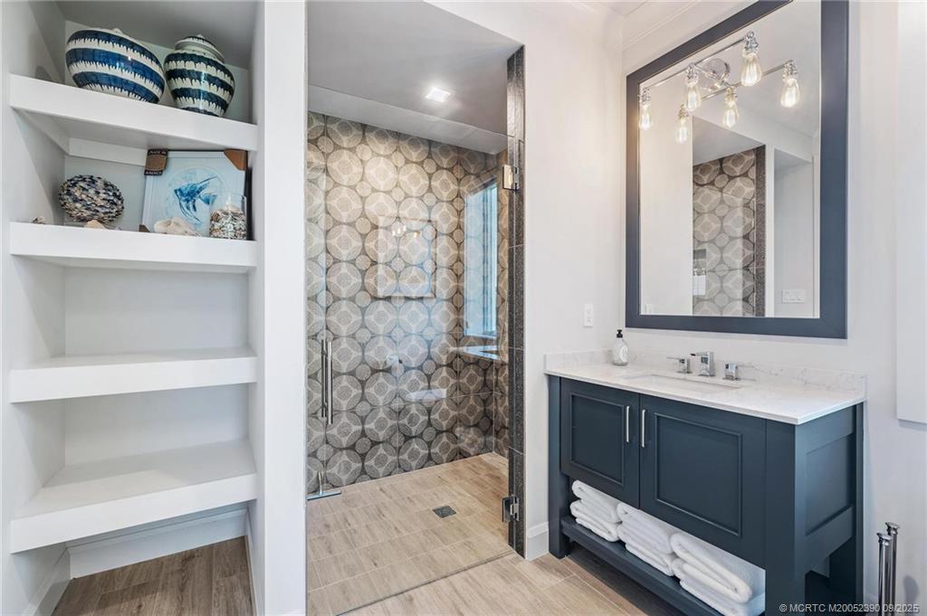 4860 Watersong Way Fort Pierce, FL 34949 - Photo 32 of 45 a bathroom with a sink a mirror and a shower