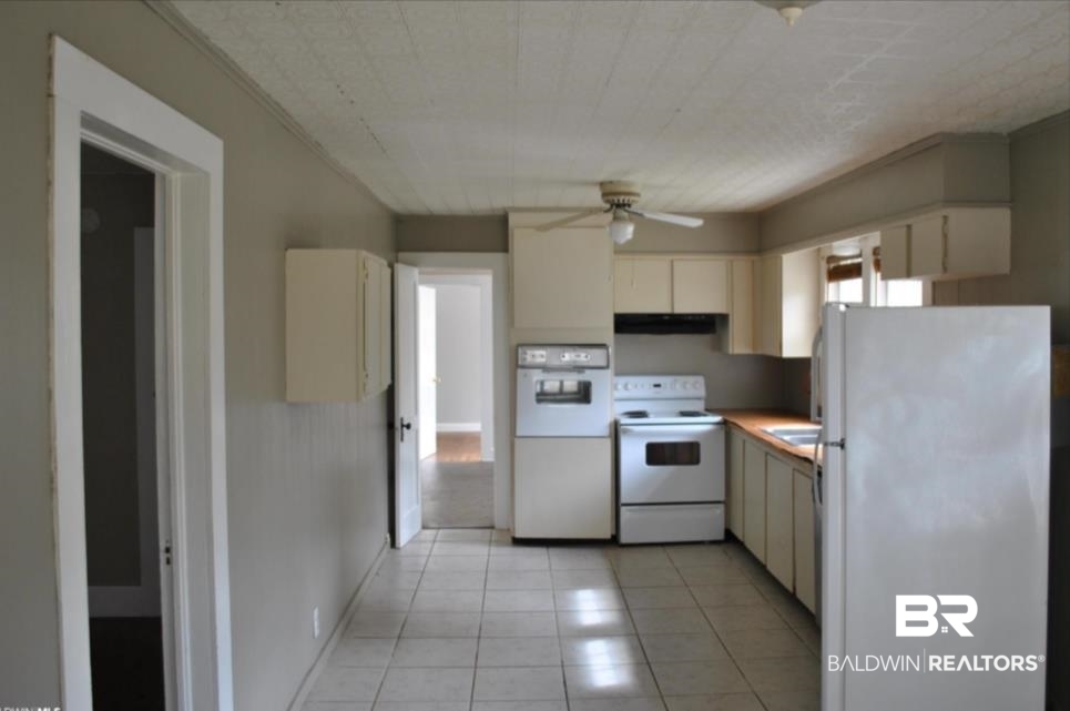 1059 Alabama Street Loxley, AL 36551 - Photo 6 of 12 Kitchen with light tile patterned flooring, cream cabinets, white appliances, and ceiling fan