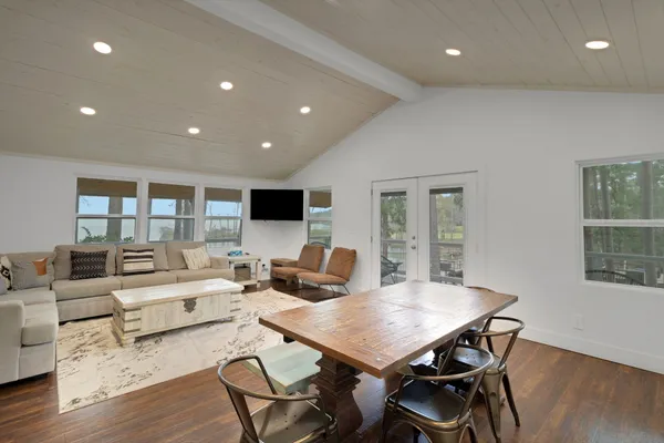 a living room with furniture a flat screen tv and wooden floor