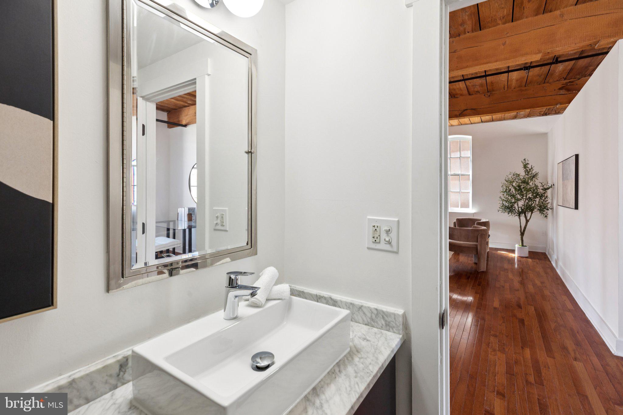 205-15 Cuthbert Street, Unit 301 Philadelphia, PA 19106 - Photo 4 of 5 a bathroom with a sink a mirror and wooden floor