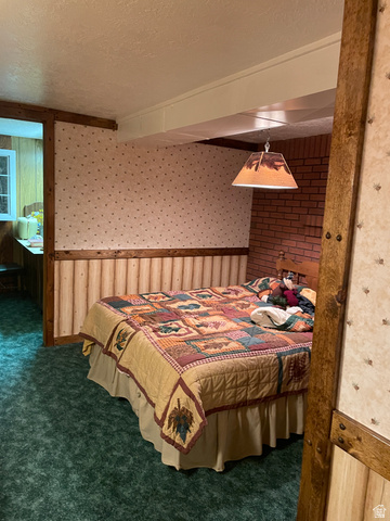 438 East Main Street Elsinore, UT 84724 - Photo 41 of 43 Room featuring textured wallpaper, wood paneling, and a brick accent wall