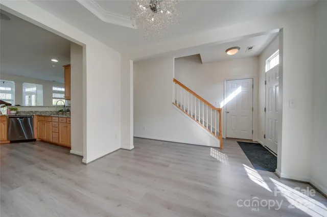 a view of a hallway with wooden floor and a kitchen