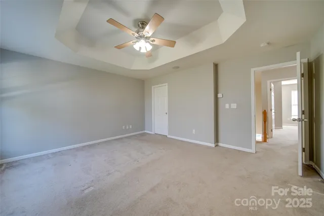 a view of an empty room with a chandelier fan