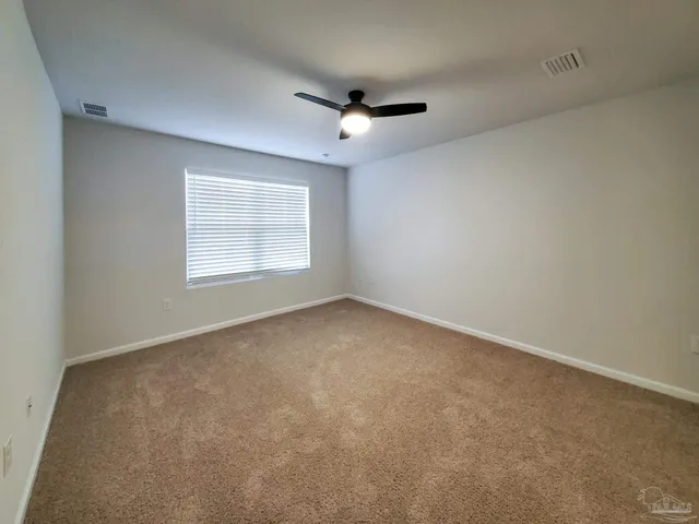 an empty room with a window and a ceiling fan