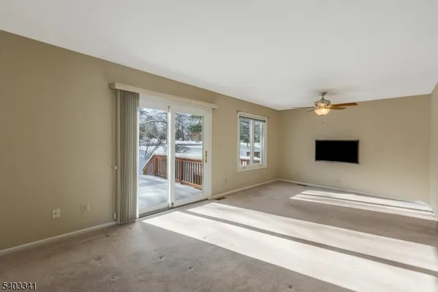 a living room with a flat screen tv and windows