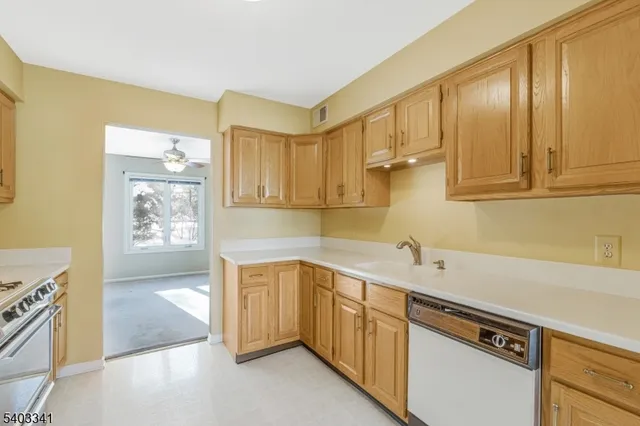 a view of a kitchen with stainless steel appliances granite countertop a sink and cabinets