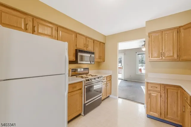 a kitchen with stainless steel appliances granite countertop a refrigerator a stove and a sink with cabinets